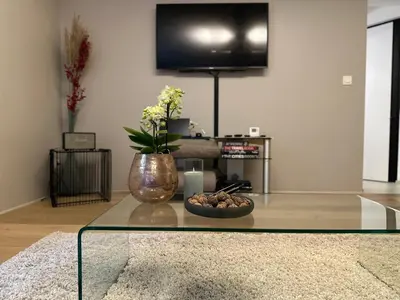 a living room with a glass table with a vase at Sweetwater Privé Wellness in Oud-Heverlee