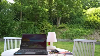 a laptop computer sitting on a table with a lamp at Sweetwater Privé Wellness in Oud-Heverlee