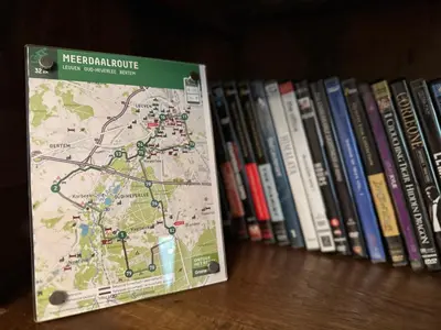 a map on a book shelf next to some books at Sweetwater Privé Wellness in Oud-Heverlee