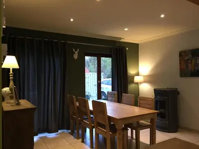 a dining room with a wooden table and chairs at Stropershuisje in Stekene