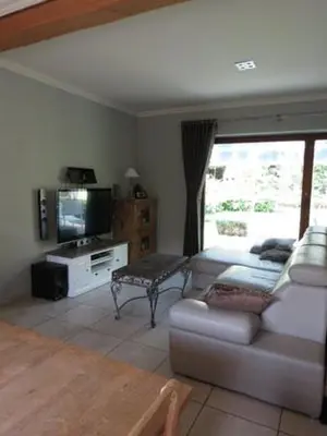 a living room with a couch and a tv at Stropershuisje in Stekene