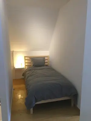 a bedroom with a bed in a white room at Stropershuisje in Stekene