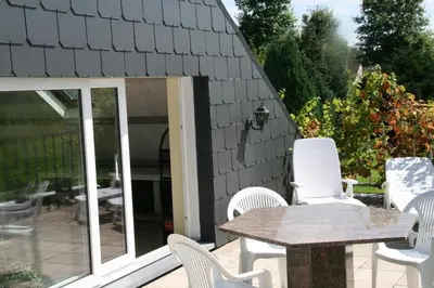 a patio with white chairs and a table at B&B Aalsters-genot in Aalst