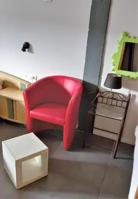 a living room with a red chair and a table at B&B Aalsters-genot in Aalst