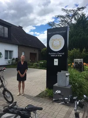 a woman standing next to a sign next to bikes at B&B Aalsters-genot in Aalst