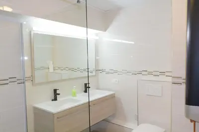 a white bathroom with a sink and a shower at Renovated Apartment in Antwerp city center in Antwerp
