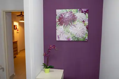 a purple wall with a picture of flowers on it at Renovated Apartment in Antwerp city center in Antwerp