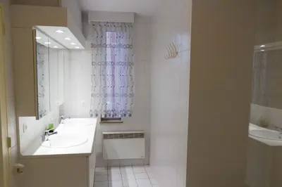 a white bathroom with two sinks and a mirror at Renovated Apartment in Antwerp city center in Antwerp