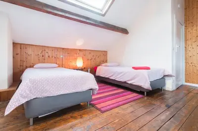 a bedroom with two beds and a purple rug at Fantastic Large House in Brussels