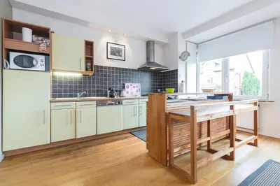 a kitchen with white cabinets and a table in it at Fantastic Large House in Brussels