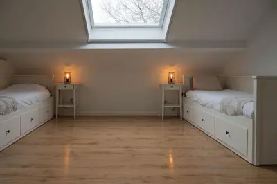 two beds in a white room with two lights on them at Huize Nassau in Zelem