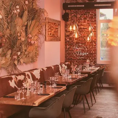 a dining room with long tables and a couch at Huize Nassau in Zelem
