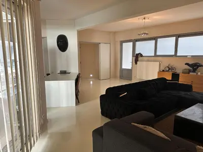 a living room with a black couch and a kitchen at Beautiful LOFT in the Center of Brussels in Brussels