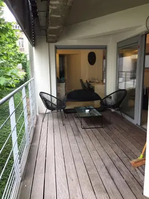 a deck with chairs and a table on a house at Beautiful LOFT in the Center of Brussels in Brussels