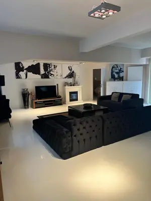 a living room with a black couch and a television at Beautiful LOFT in the Center of Brussels in Brussels