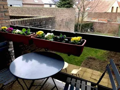 a balcony with a table and some plants on a window at African heritage Tervuren in Tervuren