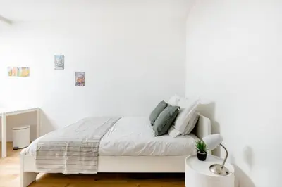 a white bed with pillows on it in a bedroom at African heritage Tervuren in Tervuren