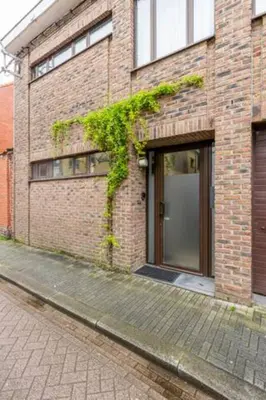a brick building with a door on a street at African heritage Tervuren in Tervuren