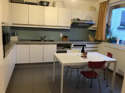 a kitchen with white cabinets and a table and chairs at African heritage Tervuren in Tervuren