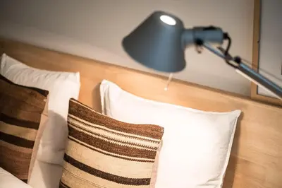 a lamp sitting on top of a bed with pillows at Great to stay Gent I rooms & apartments in Ghent