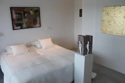 a bedroom with a white bed with two pillows at B&B Het Museum in Berlaar