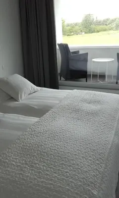 a bedroom with a bed and a chair and a window at B&B Het Museum in Berlaar