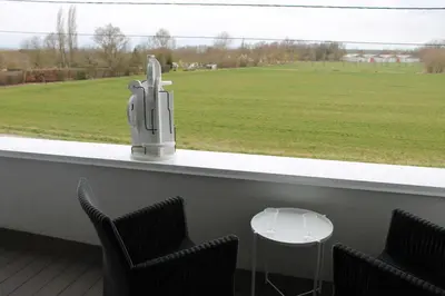 a bar with chairs and a view of a field at B&B Het Museum in Berlaar