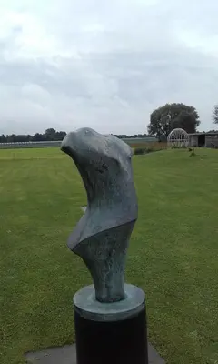 a statue of a bird in a field of grass at B&B Het Museum in Berlaar