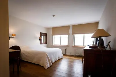 a bedroom with a white bed and two windows at Ter Heide (Kaprijke - Lembeke) in Lembeke