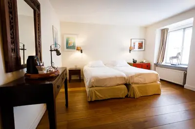 a bedroom with a bed and a desk and a mirror at Ter Heide (Kaprijke - Lembeke) in Lembeke
