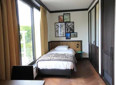 a bedroom with a bed and a large window at Getaway Brussels Airport in Zaventem