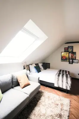 a attic bedroom with a bed and a couch at Getaway Brussels Airport in Zaventem
