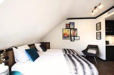 a bedroom with a white bed and a chair at Getaway Brussels Airport in Zaventem