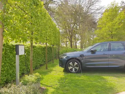 a car parked in a yard next to a hedge at B&B 't Heirweggoed in Assenede