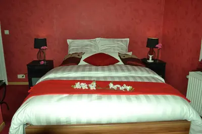 a bedroom with a large bed with red walls at Hotel Het Gasthof in Herent