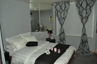 a bedroom with a white bed and a mirror at Hotel Het Gasthof in Herent