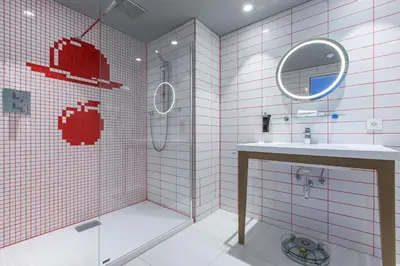 a bathroom with a shower and a sink and a mirror at Radisson RED Brussels in Brussels