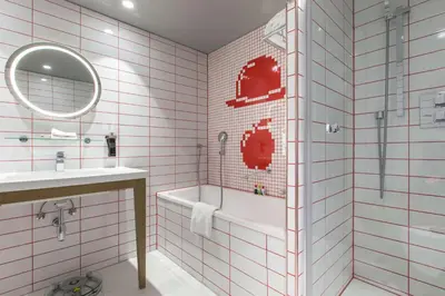 a bathroom with a tub and a sink and a mirror at Radisson RED Brussels in Brussels