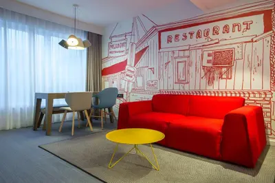 a living room with a red couch and a table at Radisson RED Brussels in Brussels