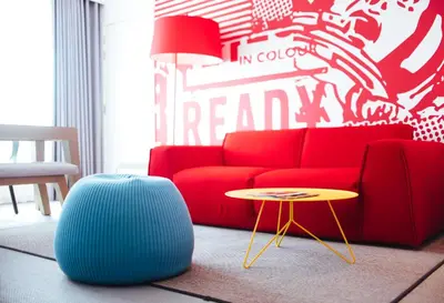 a living room with a red couch and a table at Radisson RED Brussels in Brussels