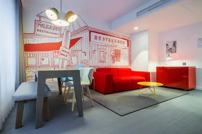 a living room with a red couch and a table at Radisson RED Brussels in Brussels