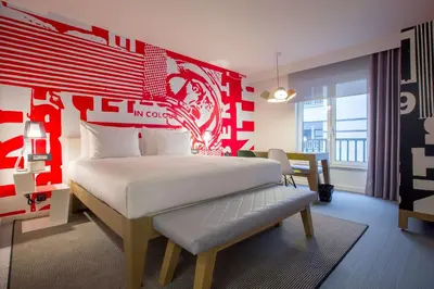 a bedroom with a bed with a red wall at Radisson RED Brussels in Brussels