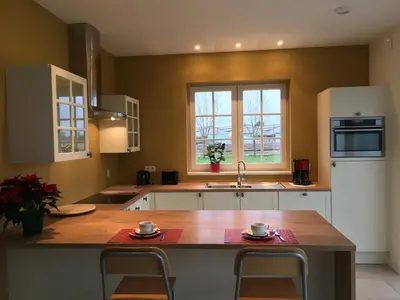 a kitchen with a wooden table and a counter top at Sint-Amands Country Escape in Sint-Amands