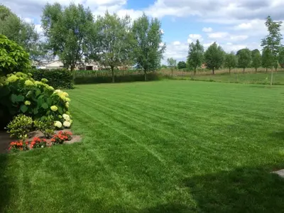 a large yard with green grass and flowers at Sint-Amands Country Escape in Sint-Amands