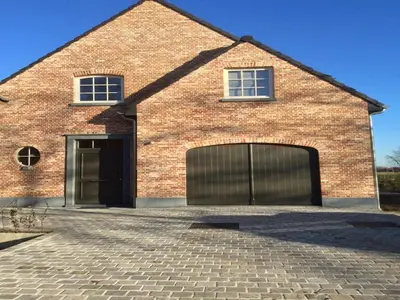 a red brick building with two garage doors at Sint-Amands Country Escape in Sint-Amands