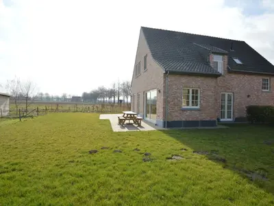 a brick house with a picnic table in a field at Sint-Amands Country Escape in Sint-Amands