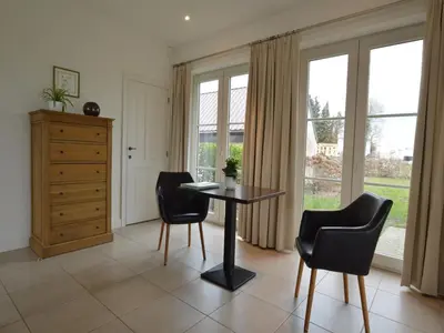 a dining room with a table and chairs and windows at Sint-Amands Country Escape in Sint-Amands