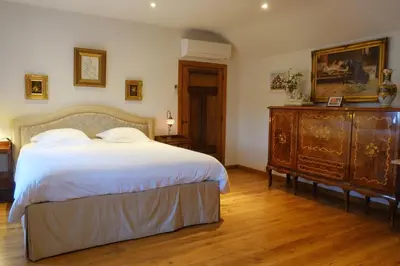 a bedroom with a large bed and a wooden dresser at B&B Domein Rodin in Oud-Turnhout