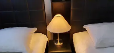 a lamp sitting on a table between two beds at Guesthouse Marie Therese in Brussels