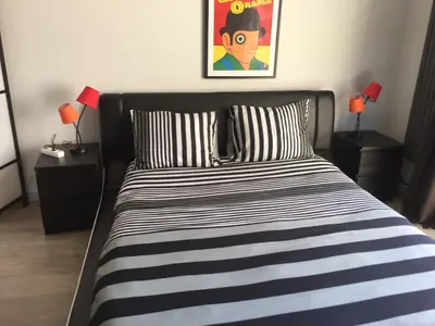 a bed with a black and white striped comforter in a bedroom at Guesthouse Marie Therese in Brussels